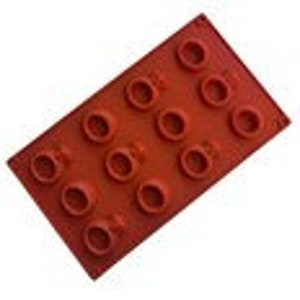 May include: Red silicone mold with 12 round cavities, shaped like a brick.
