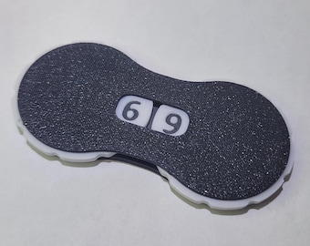 May include: A black and white counter with the numbers 6 and 9 displayed. The counter has a textured surface and a white border.