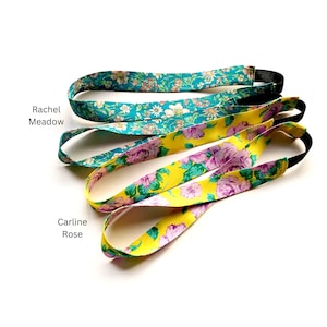 K&ouml;nnte beinhalten: Zwei Stoffstirnb&auml;nder mit elastischen R&uuml;ckenb&auml;ndern. Das obere Stirnband hat einen t&uuml;rkisfarbenen Hintergrund mit einem mehrfarbigen Blumenmuster, beschriftet als Rachel Meadow. Das untere Stirnband hat einen gelben Hintergrund mit einem rosa Blumenmuster, beschriftet als Carline Rose.