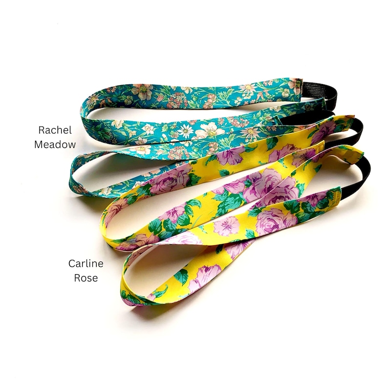 K&ouml;nnte beinhalten: Zwei Stoffstirnb&auml;nder mit elastischen R&uuml;ckenb&auml;ndern. Das obere Stirnband hat einen t&uuml;rkisfarbenen Hintergrund mit einem mehrfarbigen Blumenmuster, beschriftet als Rachel Meadow. Das untere Stirnband hat einen gelben Hintergrund mit einem rosa Blumenmuster, beschriftet als Carline Rose.