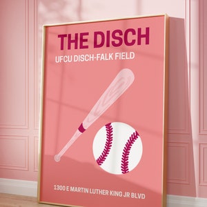 May include: A pink and gold poster with the text "THE DISCH" and "UFCU DISCH-FALK FIELD" in a bold, dark pink font. Below the text is a white baseball with red stitching and a brown baseball bat. The address "1300 E MARTIN LUTHER KING JR BLVD" is printed at the bottom of the poster.