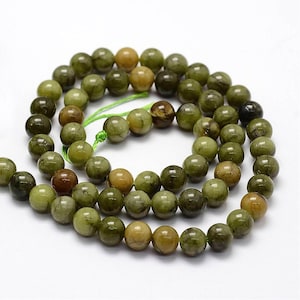 May include: A strand of green and brown jade beads. The beads are round and have a smooth, polished finish.