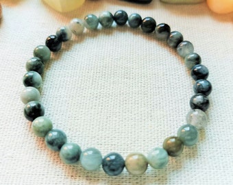 Könnte beinhalten: Ein grünes und blaues Edelstein-Armband mit runden Perlen. Die Perlen sind in der Größe abgestuft, wobei die größeren Perlen oben und die kleineren Perlen unten sind.