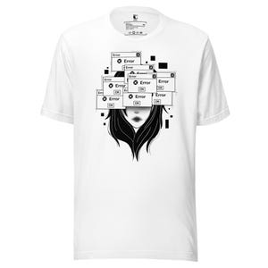 May include: A white short-sleeved t-shirt featuring a black and white graphic of a face obscured by multiple overlapping computer pop-up windows. Each window displays the text Error and an OK button, with scattered black square pixels.