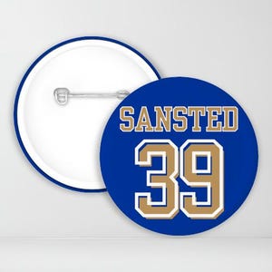 May include: Blue and gold button with the text "SANSTED 39" on it.