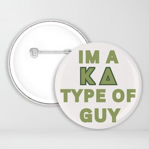 May include: A white button with a green and black design that says "I'm a KA type of guy".