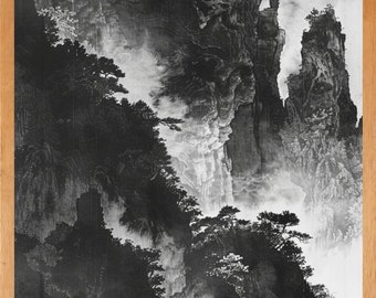 May include: Black and white landscape art print depicting a mountainous scene with trees and fog. The artwork is framed in a light brown wooden frame. The image captures a serene and natural environment.