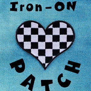 May include: A heart-shaped patch featuring a black and white checkered pattern, centered on a bright blue denim fabric. The text "Iron-ON" is printed in black above the heart, and the word "PATCH" is printed in black below the heart.