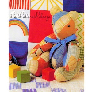 May include: A patchwork quilt with a rainbow, sun, and stripes. A patchwork teddy bear sits on the quilt with wooden blocks in front of it. The quilt is labeled "Past Patterns Palooza".