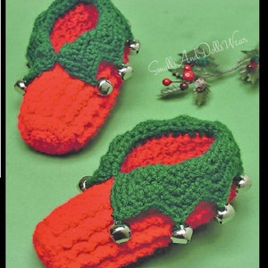 May include: A pair of red and green crocheted elf slippers with jingle bells. The slippers are made with a textured stitch and have a green crocheted cuff.