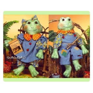 May include: Two frog dolls sitting on a bench. The frog on the left is holding a brown paper bag with the text "Brown Bug Lunch" and a butterfly graphic. The frog on the right is holding a fishing rod.