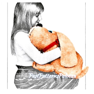 May include: A girl is hugging a large, plush, tan dog toy. The dog has a red collar and blue eyes. The girl is wearing a white sweater and a striped skirt.