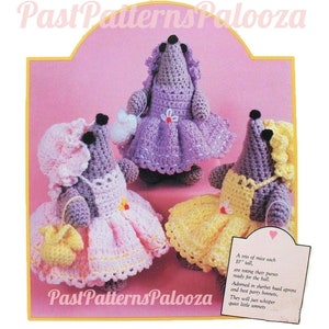 Puede incluir: Tres ratones de crochet vestidos con vestidos rosas, amarillos y morados con gorros y bolsos a juego. Los ratones miden 25 cm de alto y están listos para el baile. "Un trío de ratones de 25 cm de alto cada uno, llevando sus carteras listas para el baile. Adornados con delantales de colores pastel y sus mejores gorros de fiesta, solo susurrarán pequeños sonetos"