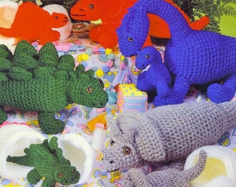 May include: A set of crocheted dinosaur toys in various colors, including green, blue, red, and gray. The dinosaurs are arranged on a white and blue patterned fabric. The image includes the text "PastPatternsPalooza".