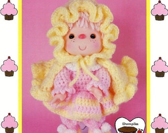 May include: Crochet pattern for a pink and yellow doll named "Pink Lemonade". The doll is wearing a yellow hooded cape and a pink dress with yellow trim. The pattern is by "Dumplin Designs" and is brought to you directly from "Cupcake Corner".
