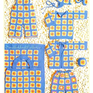 May include: A selection of handmade crochet items in a blue, yellow, and pink floral pattern. The set includes overalls, a sweater, a jacket, trousers, a hat, a bag, and a small ball. The text "Smalls And Dolls Co" is visible.