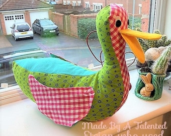 May include: A green, yellow, pink, and white patchwork duck with a gingham pattern. The duck is sitting on a windowsill. The text "Made By A Talented Etsian who used This pattern!" is written below the duck.
