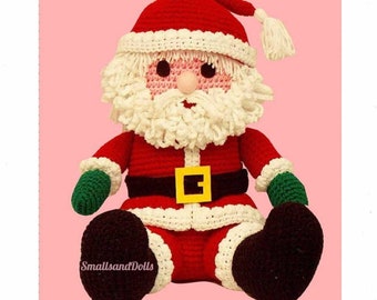 May include: A handmade crochet Santa Claus doll. The doll is primarily red with white trim, a white beard, and a red hat. It has a black belt with a gold buckle, green gloves, and brown boots. The doll is sitting down.