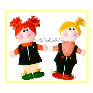 Könnte beinhalten: Ein Vintage-Nähmuster für zwei handgemachte Puppen. Das Muster zeigt eine Mädchenpuppe mit roten Haaren und eine Jungenpuppe mit blonden Haaren. Beide Puppen tragen Latzhosen und haben lächelnde Gesichter.