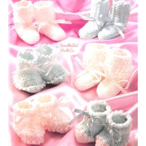 May include: Six pairs of handmade crochet baby booties in white and light blue, each featuring a delicate ribbon tie at the ankle. The booties are arranged in a grid pattern, with the text SmallsAnd DollsCo visible in the center of the image.