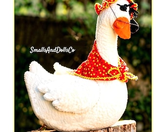 May include: A white plush goose doll wearing a red bonnet with yellow polka dots, a matching red and yellow polka dot neckerchief, and black glasses. The text SmallsAndDollsCo is visible on the left side of the white goose figure.