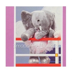 May include: A gray plush elephant wearing a pink tutu, standing on a red and white railing. The elephant has a long trunk and large ears.