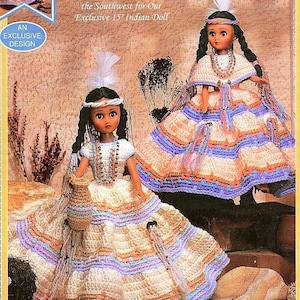May include: Two crocheted dolls dressed in traditional Native American clothing. The dolls are wearing long, colorful skirts with beaded necklaces and headbands. The dolls are standing on a brown background with a text overlay that reads "Crochet an Outfit in Shades of the Southwest for Our Exclusive 15" Indian Doll."