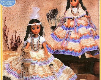 May include: Two crocheted dolls dressed in traditional Native American clothing. The dolls are wearing long, colorful skirts with beaded necklaces and headbands. The dolls are standing on a brown background with a text overlay that reads "Crochet an Outfit in Shades of the Southwest for Our Exclusive 15" Indian Doll."