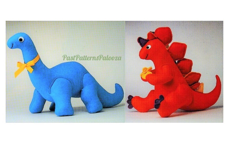 Puede incluir: Dos juguetes de peluche de dinosaurio. Un dinosaurio azul con un lazo amarillo y un dinosaurio rojo con una espalda espinosa amarilla y naranja.