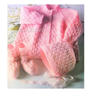 May include: A pink knitted baby set including a cardigan, hat, and booties. The set features a delicate openwork stitch pattern.