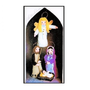May include: A handmade Christmas ornament featuring a nativity scene. The ornament includes an angel with yellow wings, Mary, Joseph, and baby Jesus in a manger. The figures are made of fabric and are set against a black background.