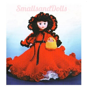 May include: Crocheted doll wearing a red dress with a black sash and a black and red hooded cape. The doll is holding a yellow basket with a red and white checkered lining. The doll has black hair and blue eyes.