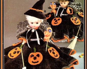 May include: Two dolls dressed as witches for Halloween. They are wearing black and orange crocheted dresses with pumpkin designs and black witch hats. Each doll is holding a broom and a mask.