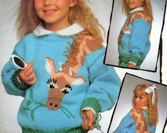 May include: A blue knitted sweater with a green trim and a brown giraffe design. The sweater has a white collar and is worn by a young girl with blonde hair.