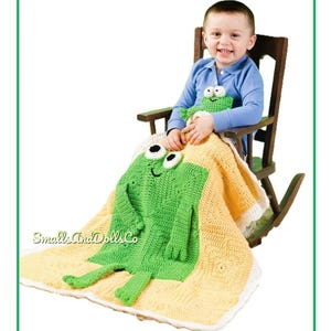 May include: A green crochet frog blanket with a matching frog toy. The blanket is yellow with a white border. The frog has large white eyes and a smiling mouth. The blanket is approximately 40 inches long.