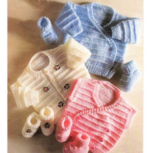 May include: Three knitted baby cardigans in pink, white, and blue with matching booties. The cardigans have a button closure and are striped. The booties are knitted with a flower design.