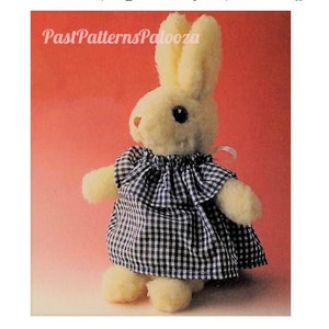 May include: A white plush bunny wearing a blue and white gingham dress. The bunny has a pink nose and brown eyes. The dress has a ruffled collar and a bow at the neck.