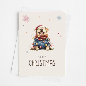 May include: A Christmas card featuring a cartoon illustration of a dog wearing a Santa hat and a blue jacket with Christmas lights wrapped around it. The dog is smiling and the text "Merry Christmas" is printed below the dog.