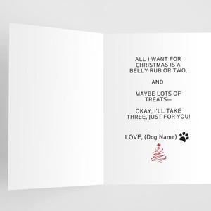 May include: A Christmas card with a black paw print and a red Christmas tree illustration. The text reads: "All I want for Christmas is a belly rub or two, and maybe lots of treats - okay, I'll take three, just for you! Love, (Dog Name)"