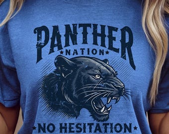 May include: Blue t-shirt with a black panther graphic. The shirt features the text "PANTHER NATION" above the panther and "NO HESITATION" below. The shirt is a heather true royal color.