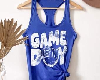 May include: Royal blue tank top with a white graphic that says "GAME DAY" with a baseball glove illustration.