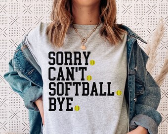 Puede incluir: Camiseta gris con el texto "SORRY CAN'T SOFTBALL BYE" en negro con iconos de softball amarillos.