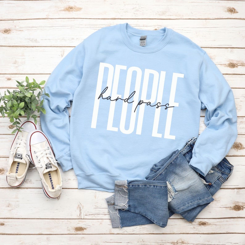 Puede incluir: Sudadera azul claro con el texto "PEOPLE hard pass" en letras blancas.