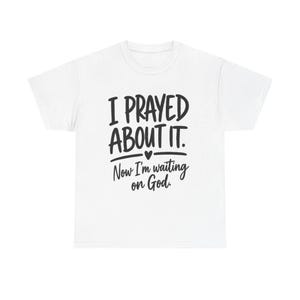 May include: A white short-sleeved t-shirt featuring black text that reads I PRAYED ABOUT IT. with a small heart icon below, followed by the text Now I'm waiting on God. The design is centered on the front of the garment in a mix of bold and script fonts.