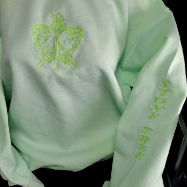 Dyed light neon green sweatshirt with glow in the dark embroidered dagger butterfly design and words on sleeve