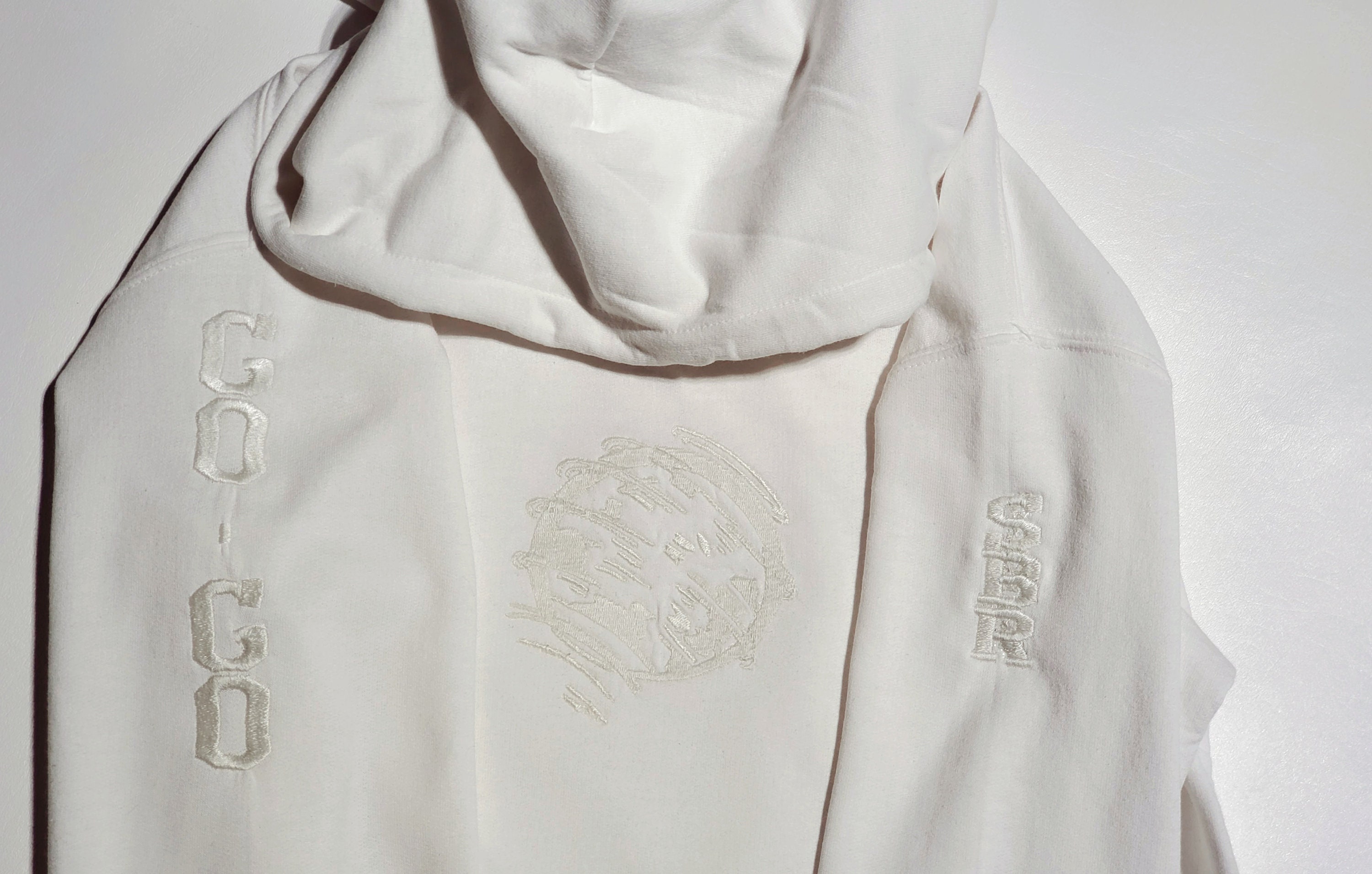白地に白の刺繍が施された回転する惑星またはボール、想像してみてくださいパーカーまたはスウェットシャツ