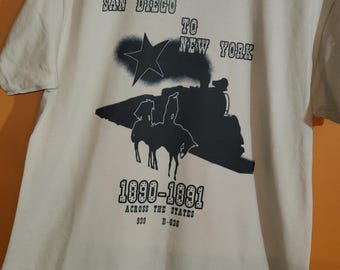 Camiseta color arena y diseño de vaquero y jockey en negro/carbón.