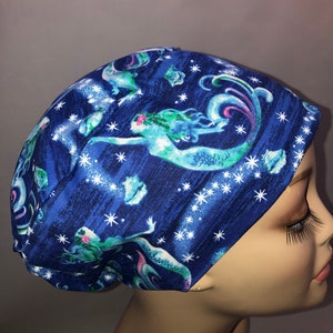 May include: A blue scrub hat with a mermaid and star pattern. The hat is made of a soft, comfortable fabric and is perfect for nurses, doctors, and other healthcare professionals.