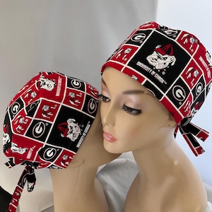 May include: Two red and black patterned surgical caps with the University of Georgia logo and mascot. The caps have a tie at the back.