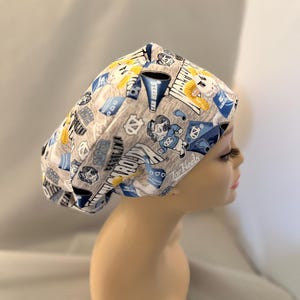 May include: Gray and blue patterned surgical scrub hat with a blue and white logo that says "Tar Heels".